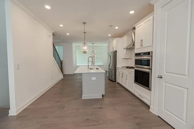 a kitchen with kitchen island stainless steel appliances a stove a sink and a refrigerator