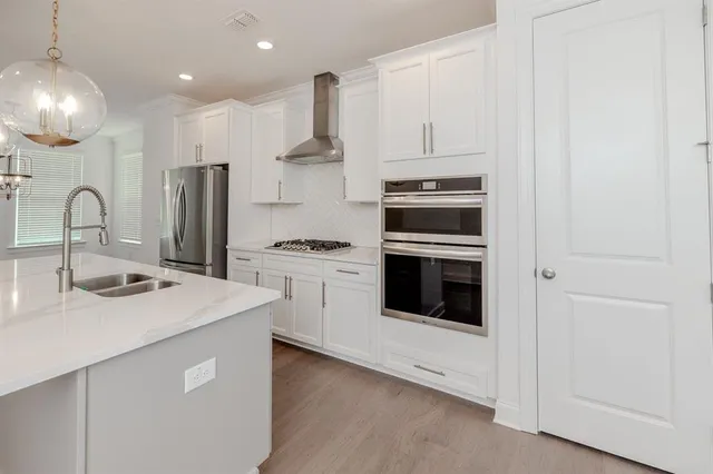 a kitchen with kitchen island a stove cabinets and a wooden floor