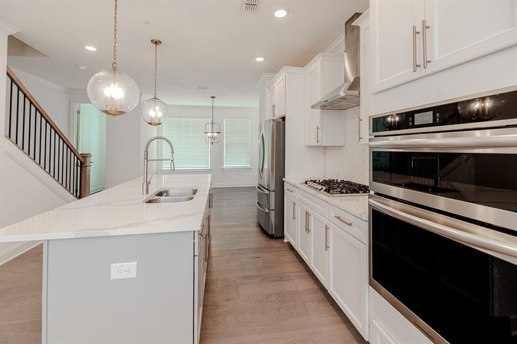 6595 Beacon Drive Atlanta, GA 30328 - Photo 16 of 36 a kitchen with kitchen island a stove cabinets and a wooden floor