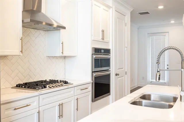 a kitchen with stainless steel appliances kitchen island a refrigerator sink and cabinets