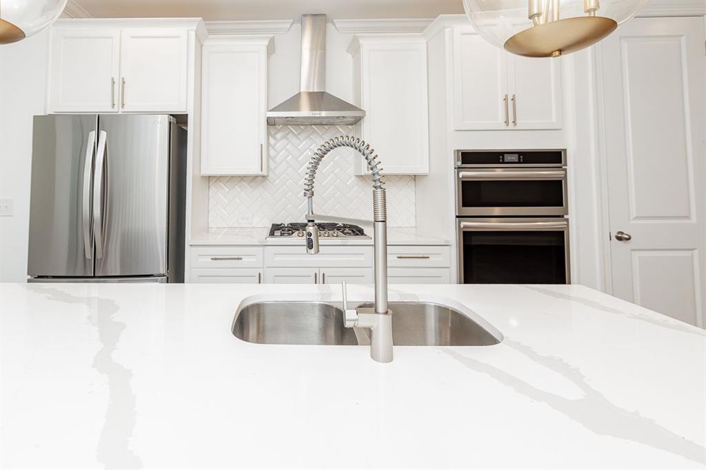 6595 Beacon Drive Atlanta, GA 30328 - Photo 18 of 36 a kitchen with stainless steel appliances kitchen island a refrigerator sink and cabinets