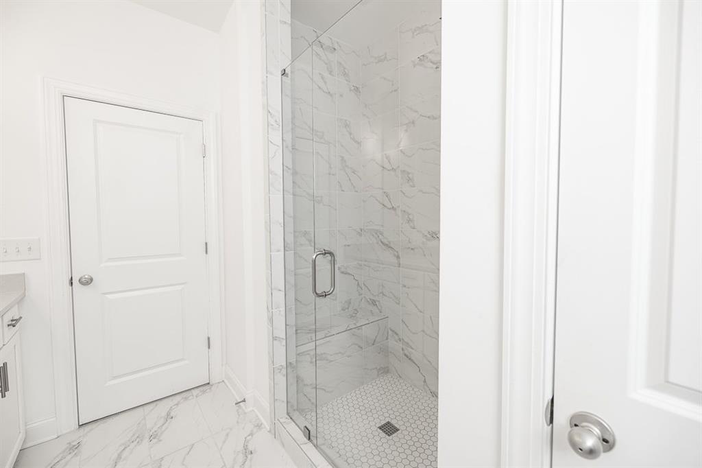 6595 Beacon Drive Atlanta, GA 30328 - Photo 33 of 36 a bathroom with a glass shower door