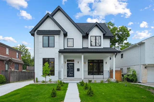 a front view of a house with a yard and potted plants