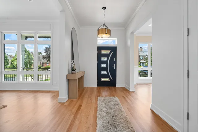 a view of a hallway with wooden floor and a living room