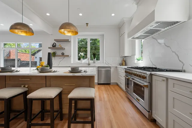 a kitchen with stainless steel appliances granite countertop a stove a sink and a microwave