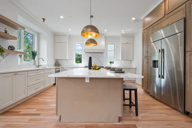 a kitchen with stainless steel appliances granite countertop a sink a stove and a refrigerator