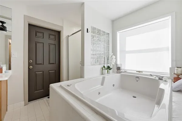 a bathroom with a tub a sink and a window