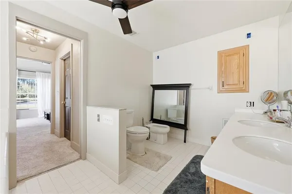 a spacious bathroom with a sink a toilet and a mirror