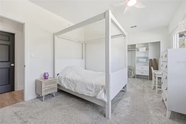 a bedroom with a bed and a refrigerator