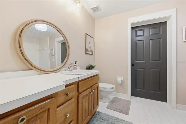 a bathroom with a toilet a sink a mirror and a shower