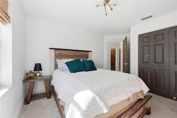 a bed sitting in a bedroom and wooden floor