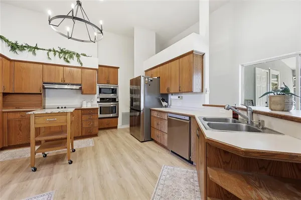 a kitchen with a sink appliances cabinets and furniture