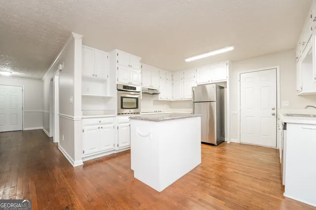 a kitchen with refrigerator cabinets and wooden floor