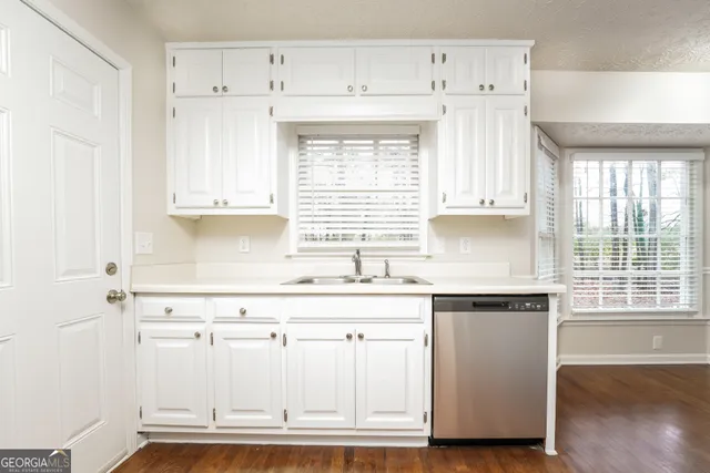 a kitchen with granite countertop white cabinets and white appliances