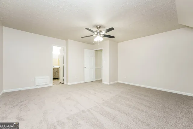 an empty room with fan and a ceiling fan