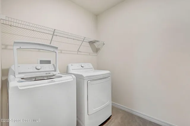 an empty room with a chandelier fan and windows