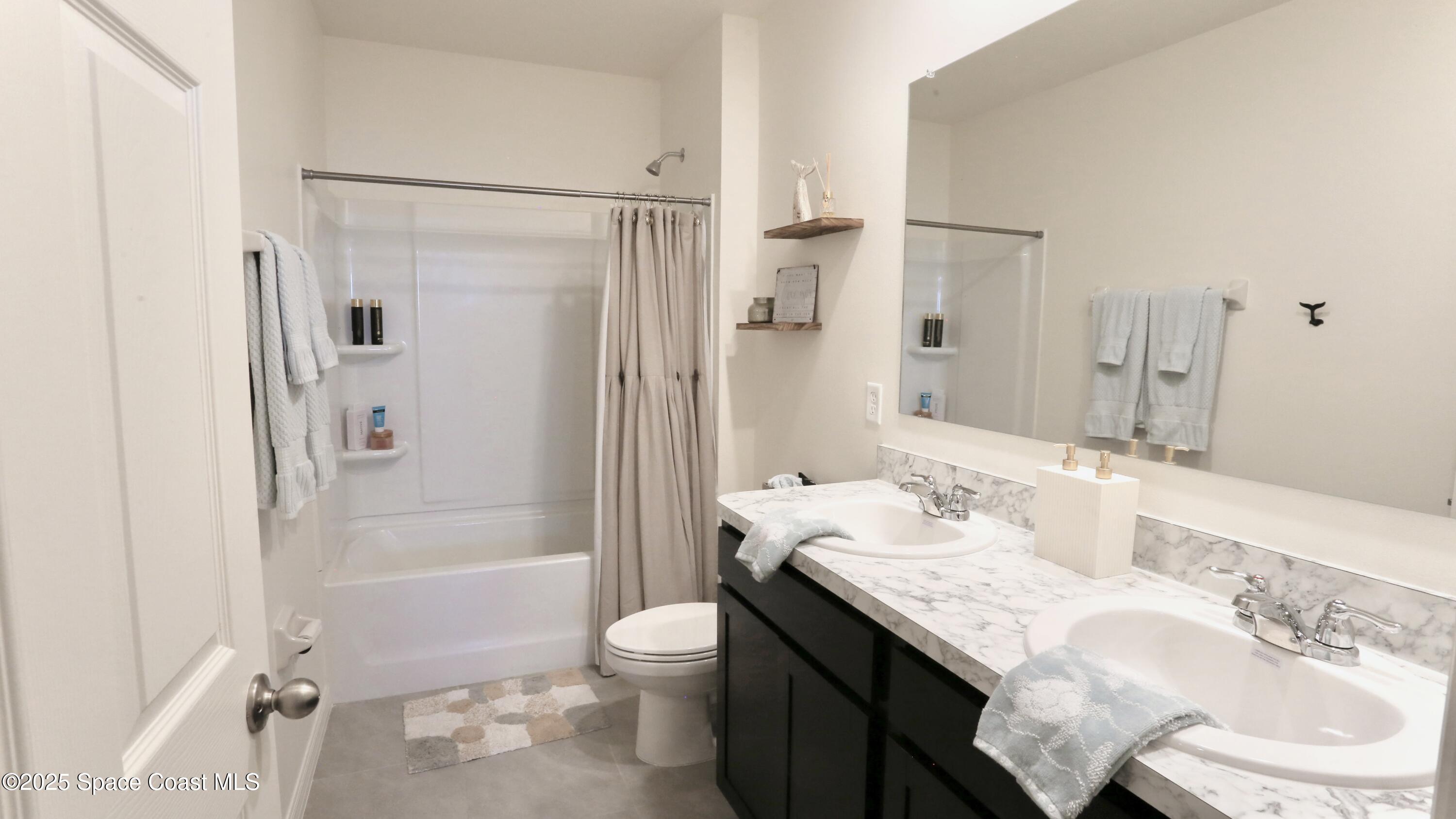 1217 Casey Avenue Rockledge, FL 32955 - Photo 39 of 49 a bathroom with a granite countertop sink toilet and shower