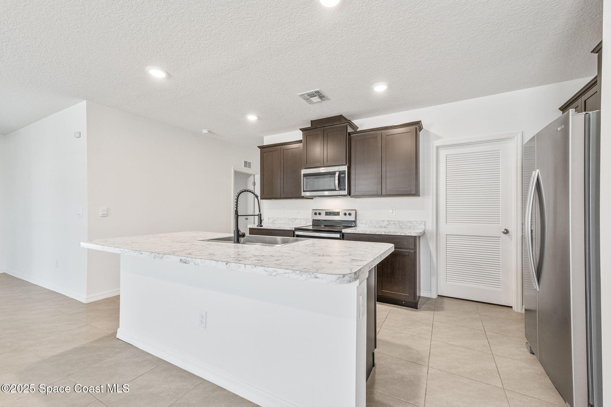 1217 Casey Avenue Rockledge, FL 32955 - Photo 5 of 49 a kitchen with stainless steel appliances granite countertop a sink and a refrigerator