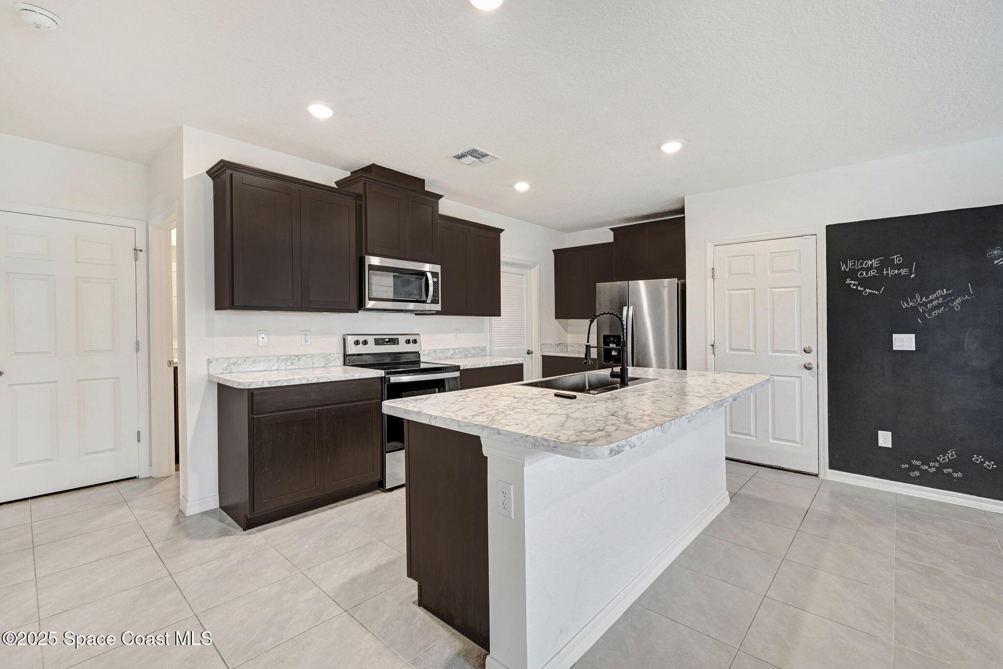 1217 Casey Avenue Rockledge, FL 32955 - Photo 6 of 49 a large kitchen with stainless steel appliances granite countertop a stove a sink a refrigerator and a microwave