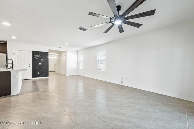 an empty room with fan and a ceiling fan