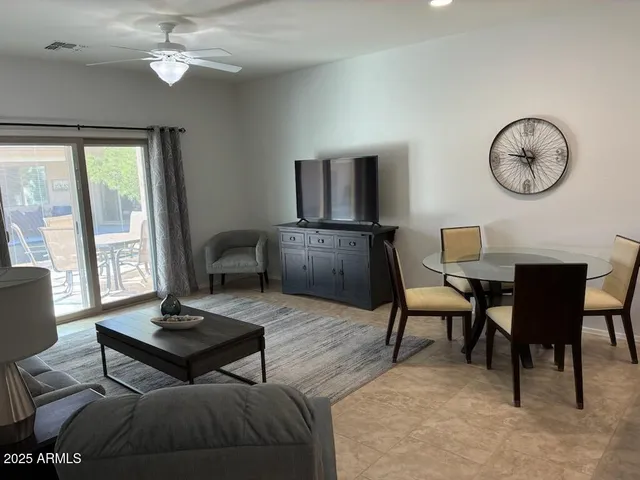 a living room with couches and a dining table with kitchen view