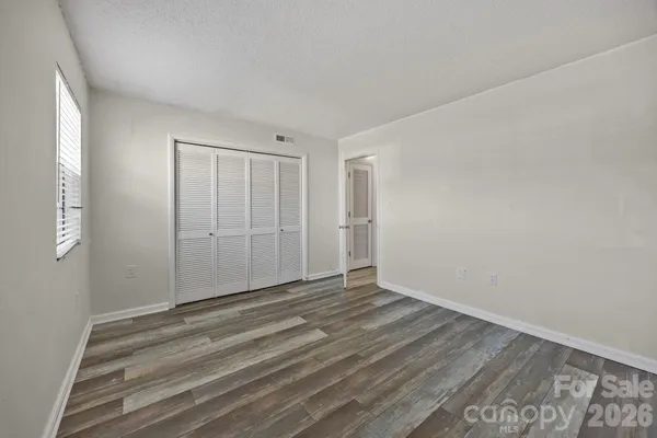 a view of an empty room with wooden floor