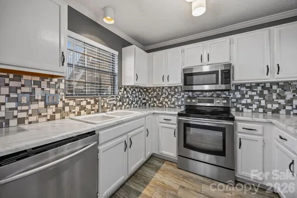 a kitchen with granite countertop a sink stove and microwave