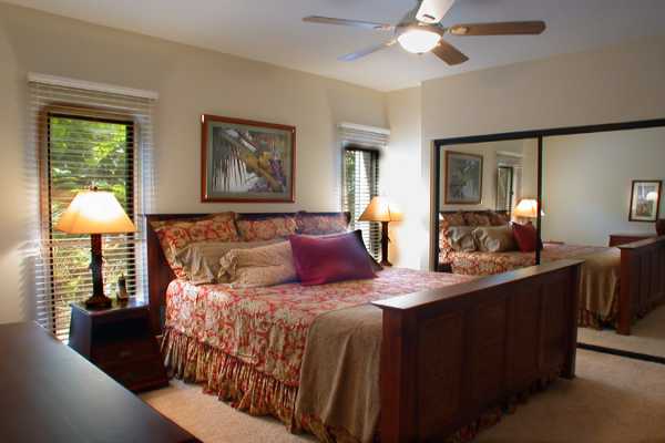 366 Papaloa Road, Unit 1C Kapaa, HI 96746 - Photo 9 of 11 a bedroom with a large bed and a chandelier