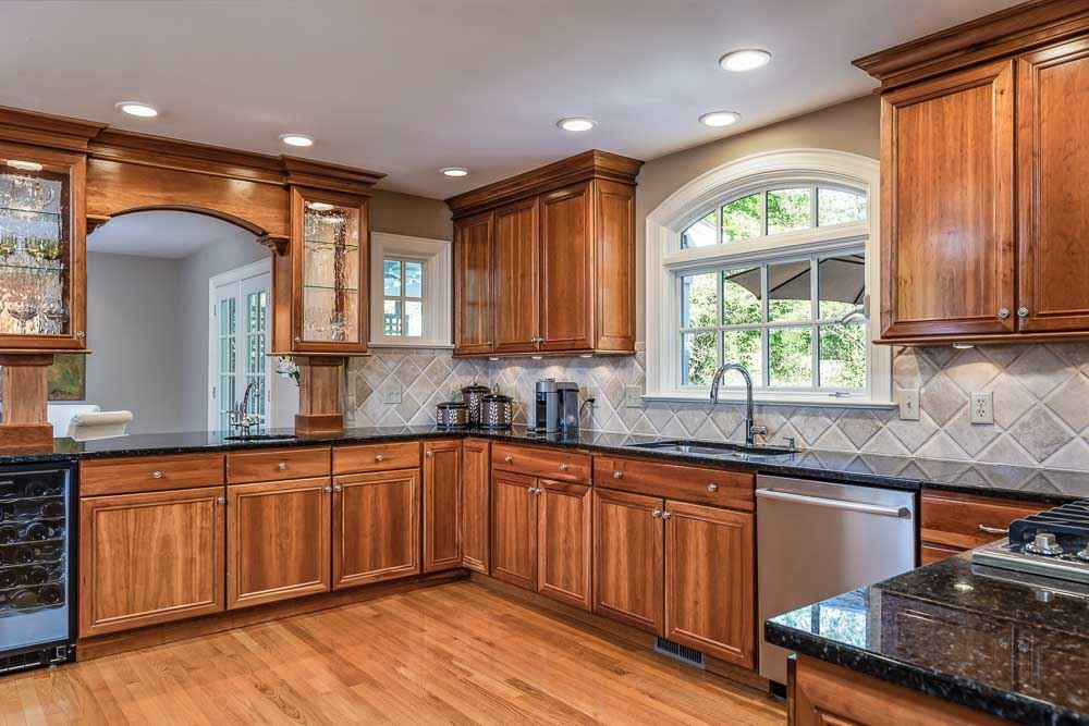 3000 Upland Circle Raleigh, NC 27607 - Photo 5 of 30 a kitchen with stainless steel appliances granite countertop wooden cabinets a sink and dishwasher with wooden floor