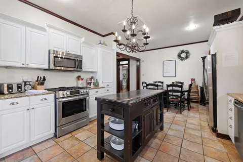 a kitchen with stainless steel appliances granite countertop a stove a sink and a refrigerator