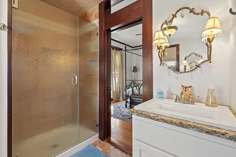 a bathroom with a granite countertop sink and a mirror