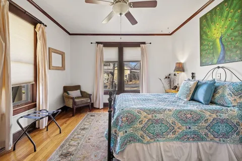 a bedroom with a bed couch and a large window