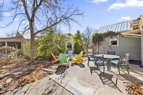 a view of a patio with table and chairs and floor to ceiling window
