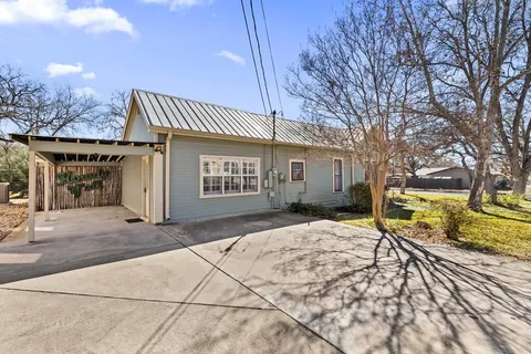 a view of a house with snow on the side of the road