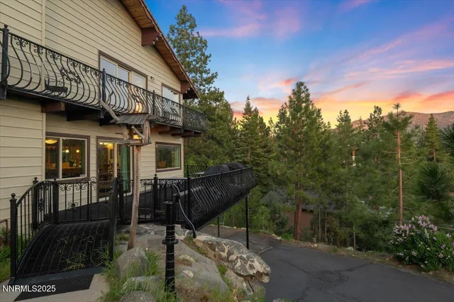 a bedroom with a large bed couch and two large window