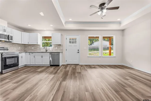 a view of a kitchen with a sink cabinets wooden floor and a window