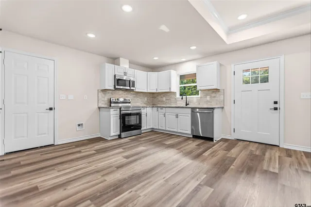 a view of a kitchen with a sink cabinets and wooden floor