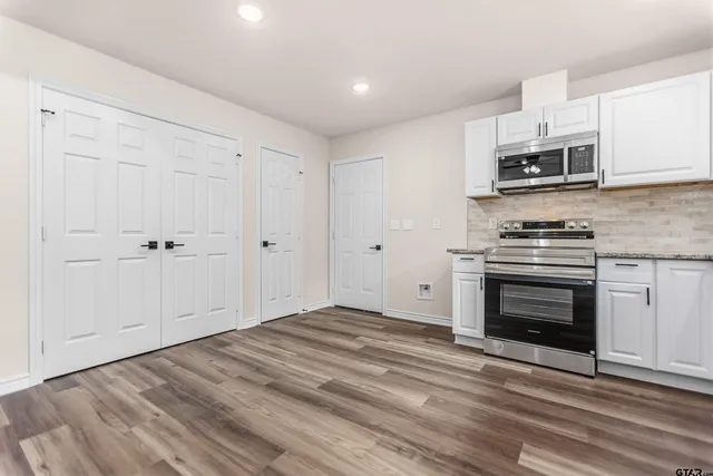 a kitchen with stainless steel appliances granite countertop a stove and a microwave