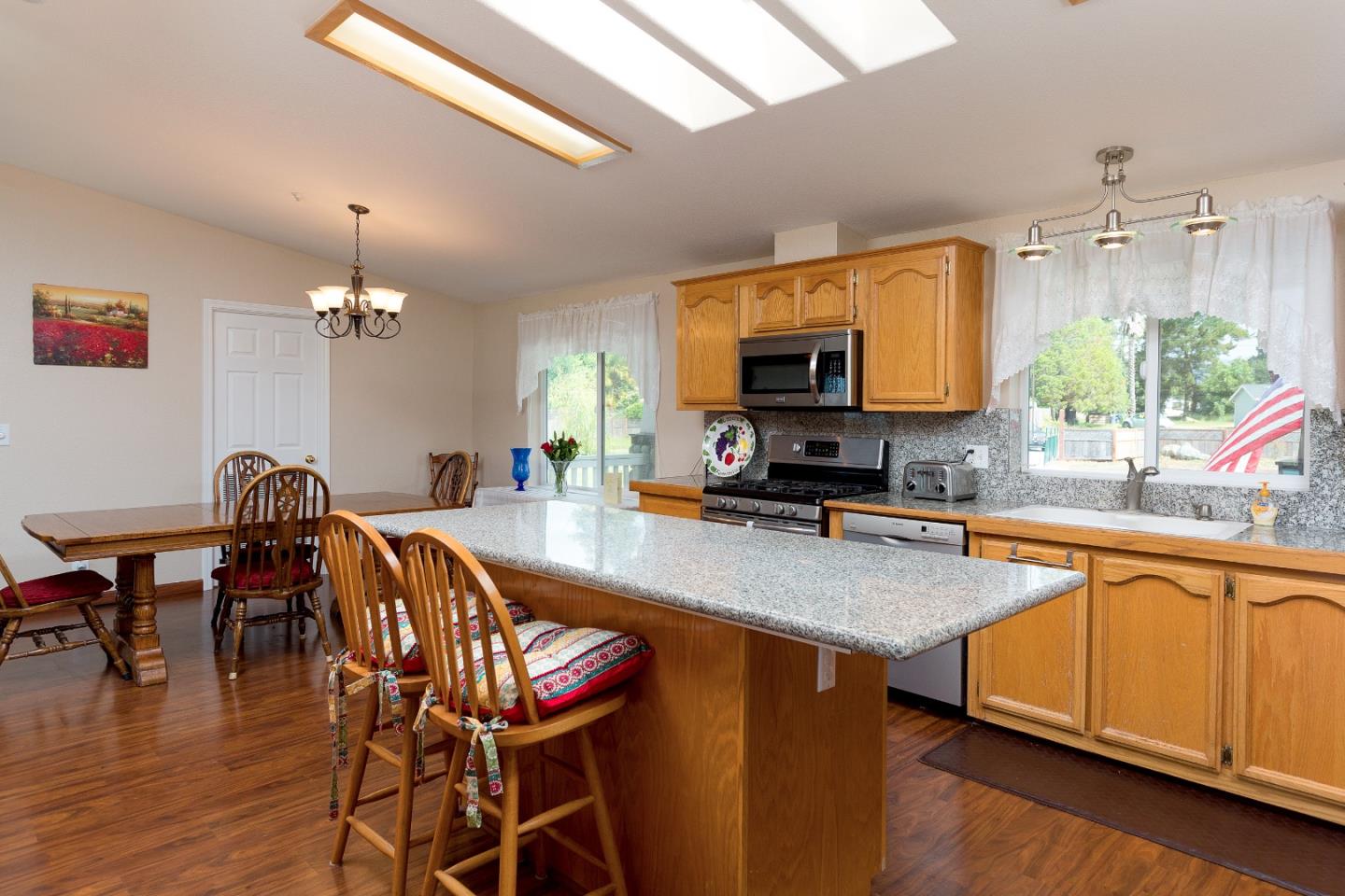 275 Orchard View Drive Watsonville, CA 95076 - Photo 7 of 25 a kitchen with stainless steel appliances granite countertop a stove top oven a sink a dining table and chairs with wooden floor