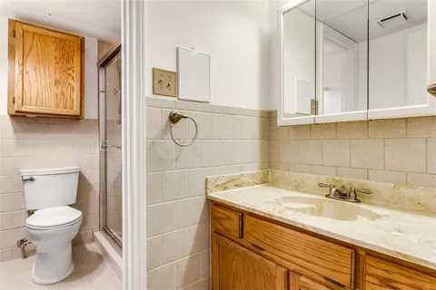 a bathroom with a granite countertop sink toilet and shower