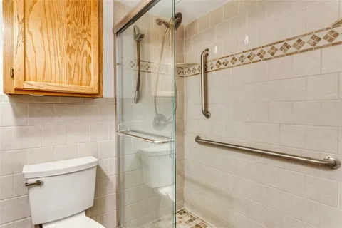 a bathroom with a granite countertop shower and a toilet