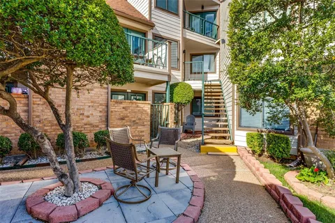 a view of a patio with table and chairs potted plants and a large tree