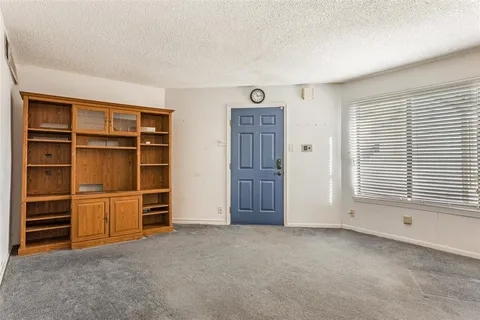 a view of an empty room with a window and storage