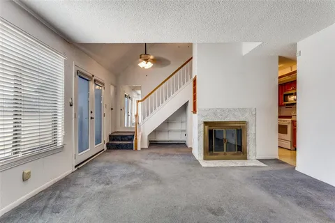 a view of an empty room with a fireplace and a window