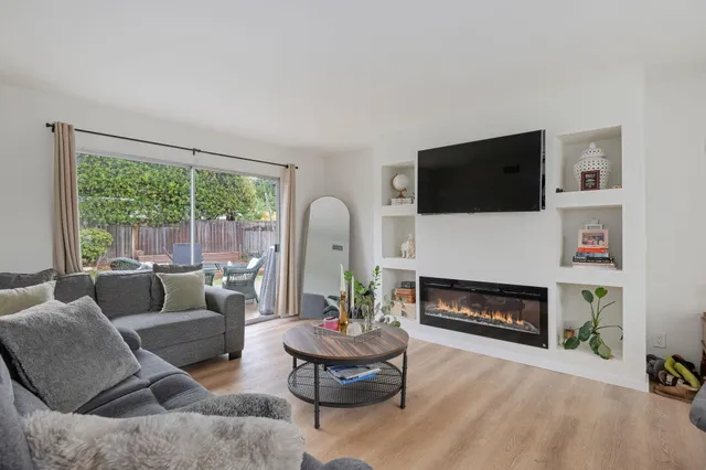 a living room with furniture a flat screen tv and a fireplace