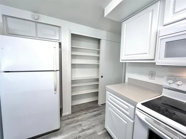a kitchen with a refrigerator and a stove top oven