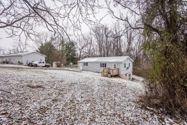 a view of a house with a yard covered with snow