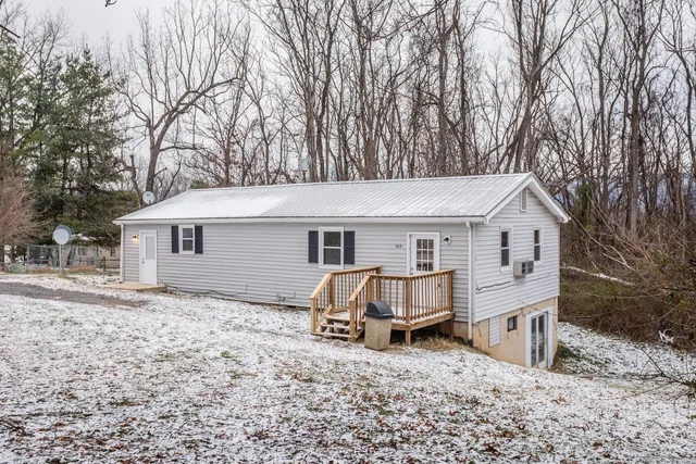 a view of a house with a yard covered in snow