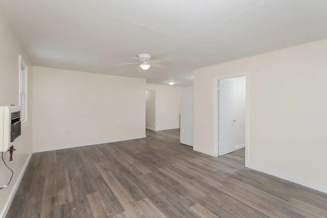 a view of an empty room with wooden floor