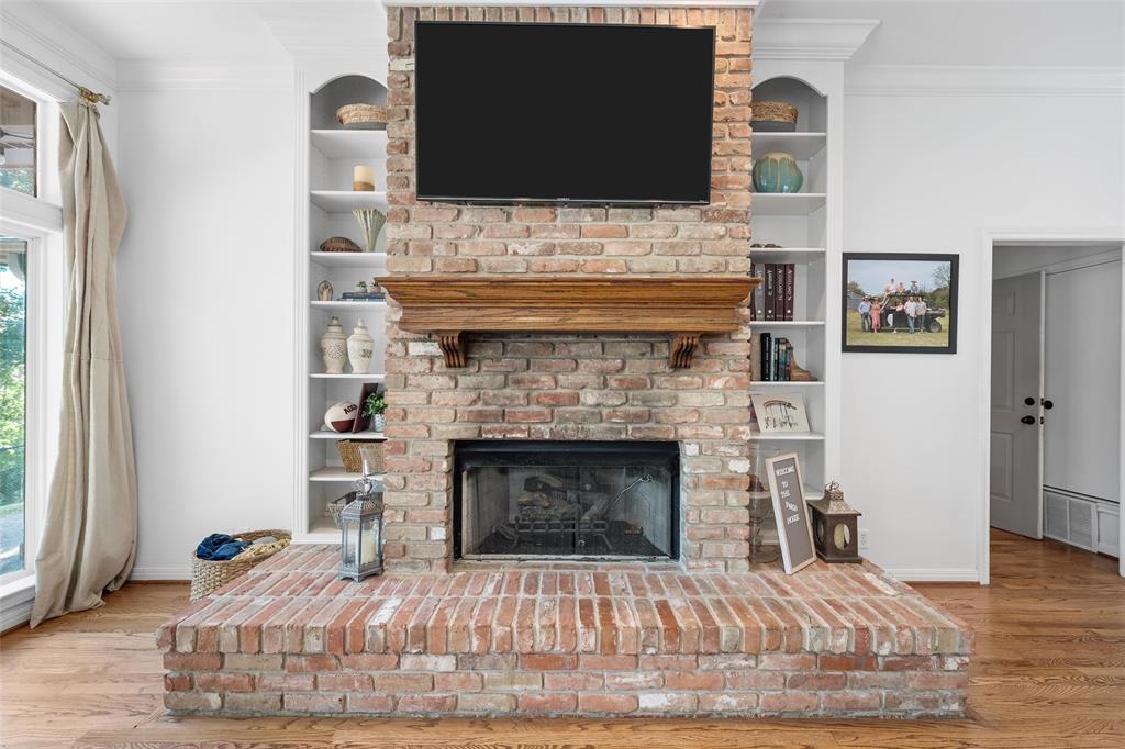 1396 Eagle Canyon Drive China Spring, TX 76633 - Photo 11 of 40 Living area with ornamental molding, wood finished floors, healthy amount of natural light, and a fireplace